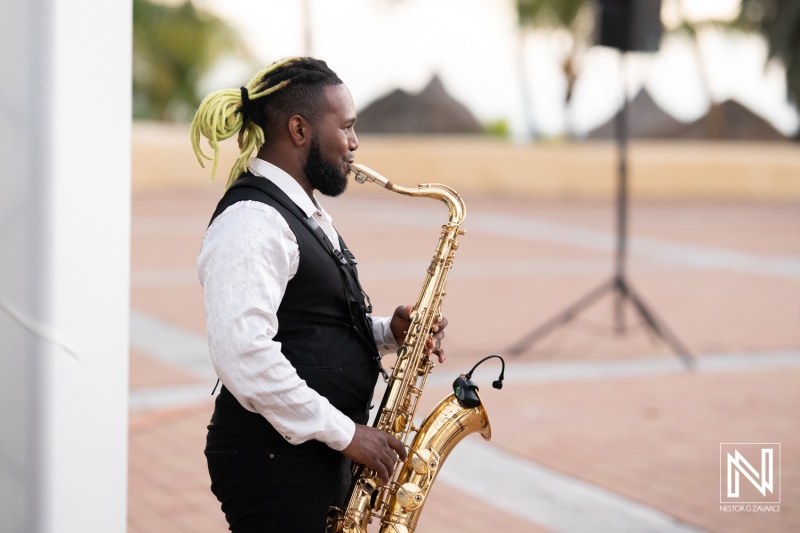 Musician performing on a saxophone during a wedding ceremony at Avila Beach Hotel in Curacao against a beautiful tropical backdrop