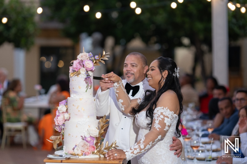 Wedding celebration at Avila Beach Hotel in Curacao featuring a couple cutting their beautiful cake surrounded by their loved ones