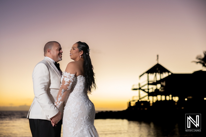 Couple exchanges vows at beautiful sunset wedding in Curacao with Avila Beach Hotel as picturesque backdrop