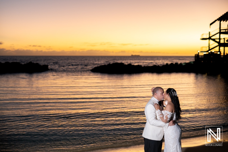 Couple shares a romantic moment at sunset on the beach after their wedding ceremony at Avila Beach Hotel in Curacao