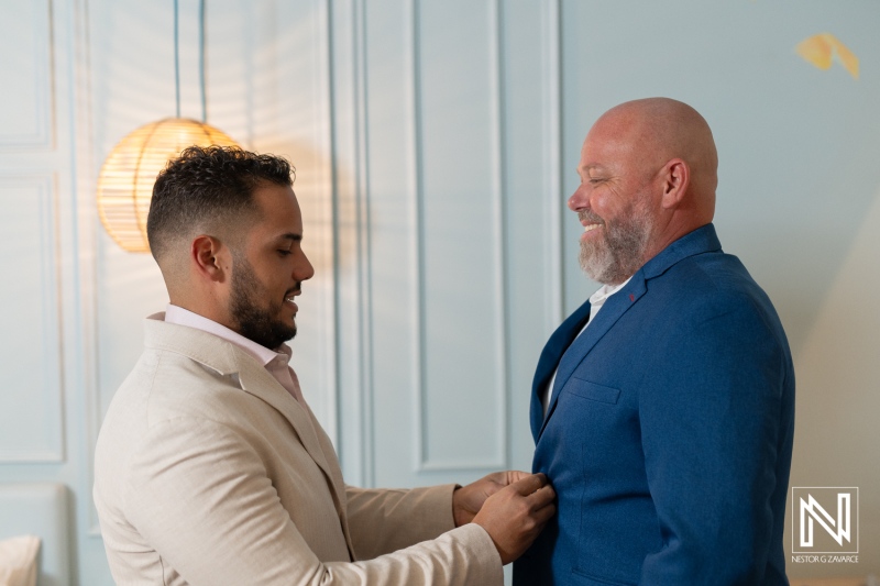 Groom preparing for wedding ceremony at Renaissance Wind Creek Curacao Resort in a stylish blue suit