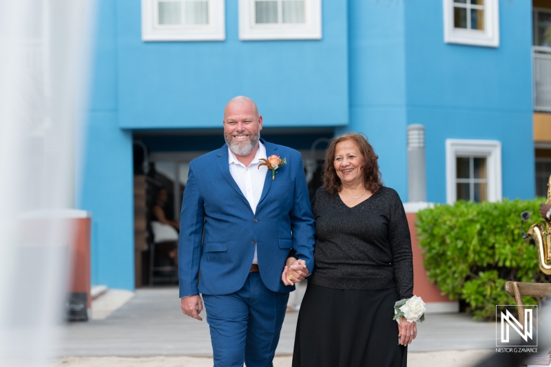 Couple walks hand in hand during wedding ceremony at Renaissance Wind Creek Curacao Resort
