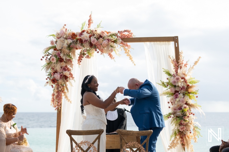 Beautiful wedding ceremony at Renaissance Wind Creek Curacao Resort with stunning floral arrangements by the beach