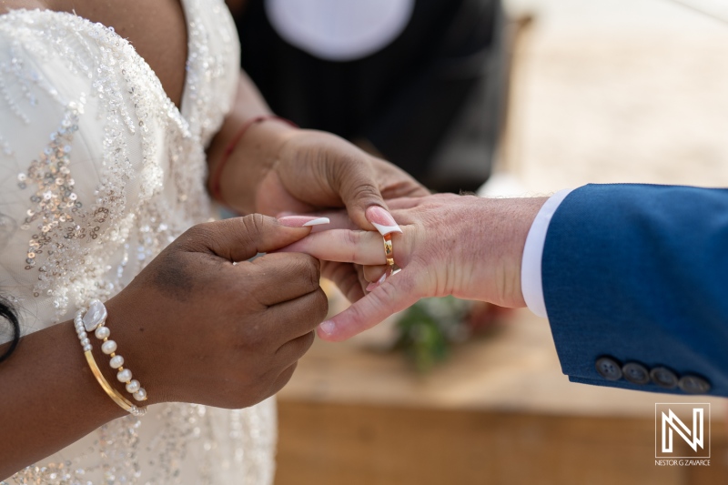Couple exchanges wedding rings on a beautiful day in Curacao at Renaissance Wind Creek Curacao Resort