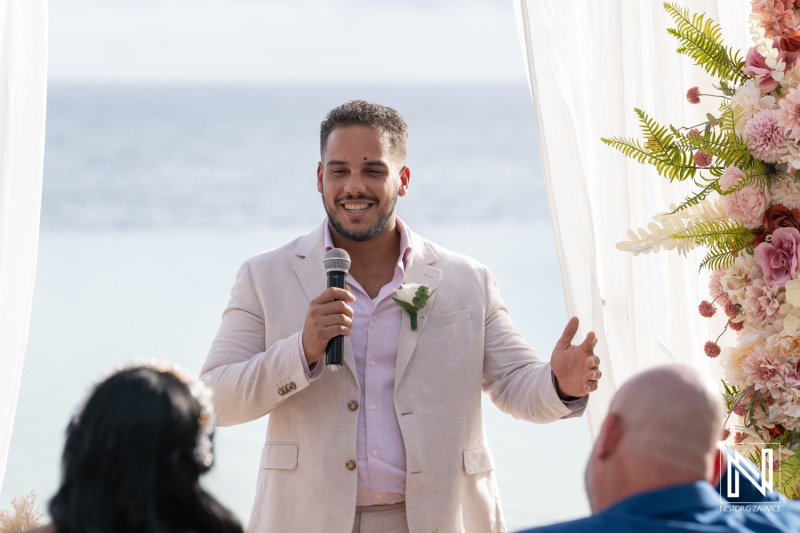 Groom delivering heartfelt speech during sunset wedding ceremony at Renaissance Wind Creek Curacao Resort