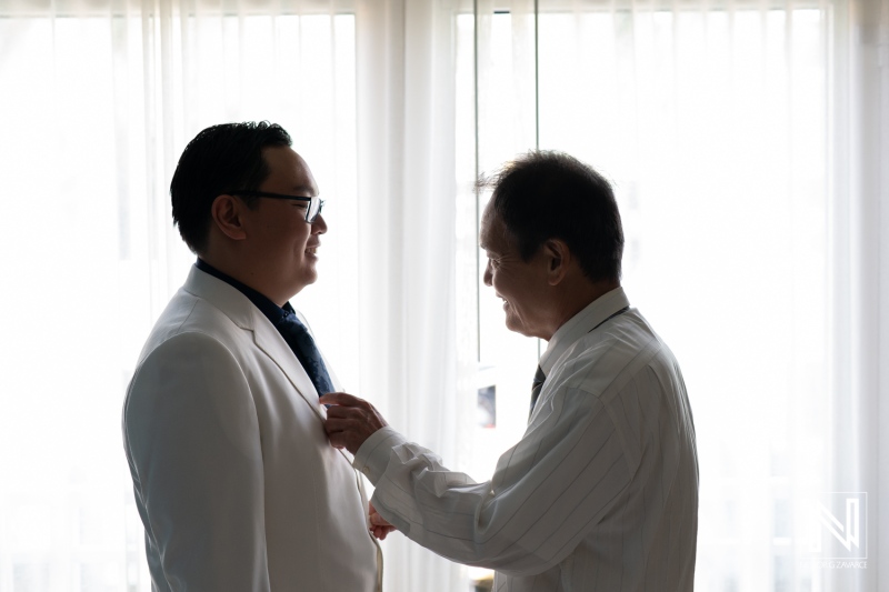 Groom and father adjusting attire before wedding ceremony in Curacao at Renaissance Wind Creek Resort