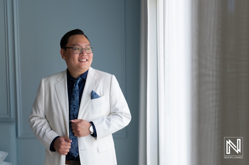 Groom prepares for wedding ceremony at Renaissance Wind Creek Curacao Resort in a stylish suit