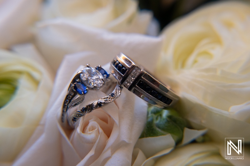 Ceremony rings beautifully displayed among white roses in Curacao wedding at Renaissance Wind Creek Resort