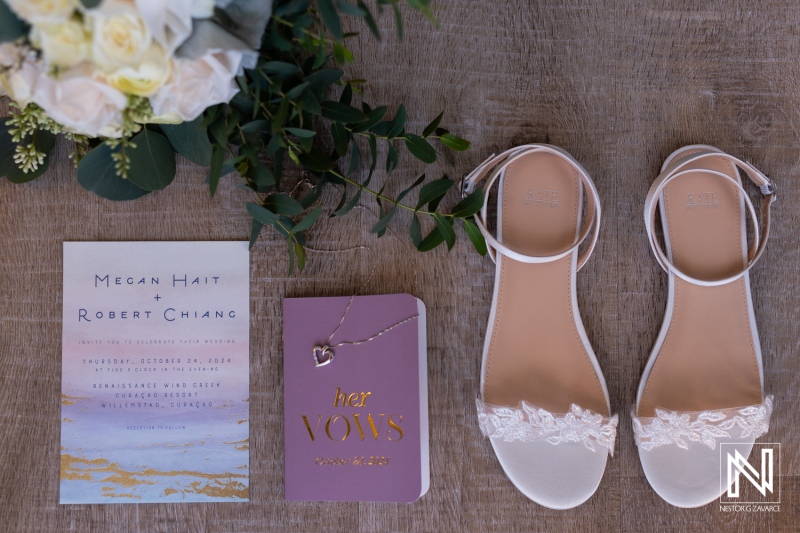 Elegant wedding details displayed at Renaissance Wind Creek Curacao Resort featuring wedding invitation and bridal shoes