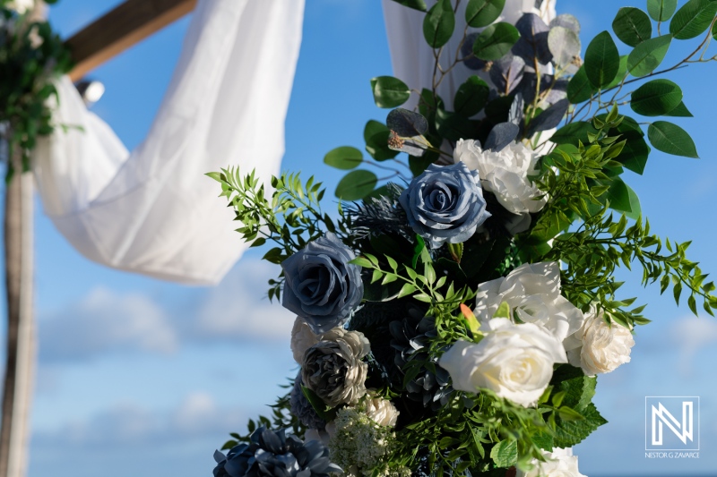 Beautiful wedding floral arrangement at Renaissance Wind Creek Curacao Resort with blue roses and greenery against a stunning sky backdrop