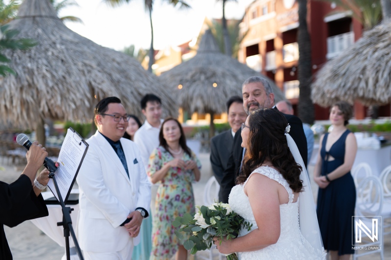 Wedding ceremony taking place on the beach at Renaissance Wind Creek Curacao Resort with guests witnessing the joyous occasion