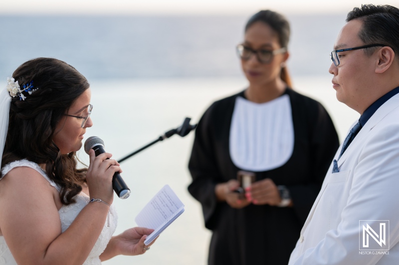 Couple exchanges vows during a romantic wedding ceremony at Renaissance Wind Creek Curacao Resort by the ocean