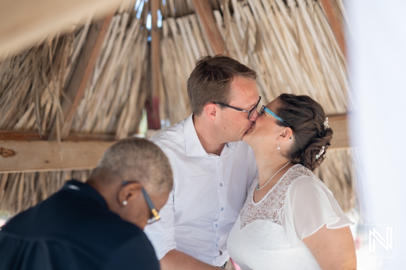 Couple exchanges vows and shares a kiss in a charming wedding ceremony at Daaibooi, Curacao during a sunny afternoon