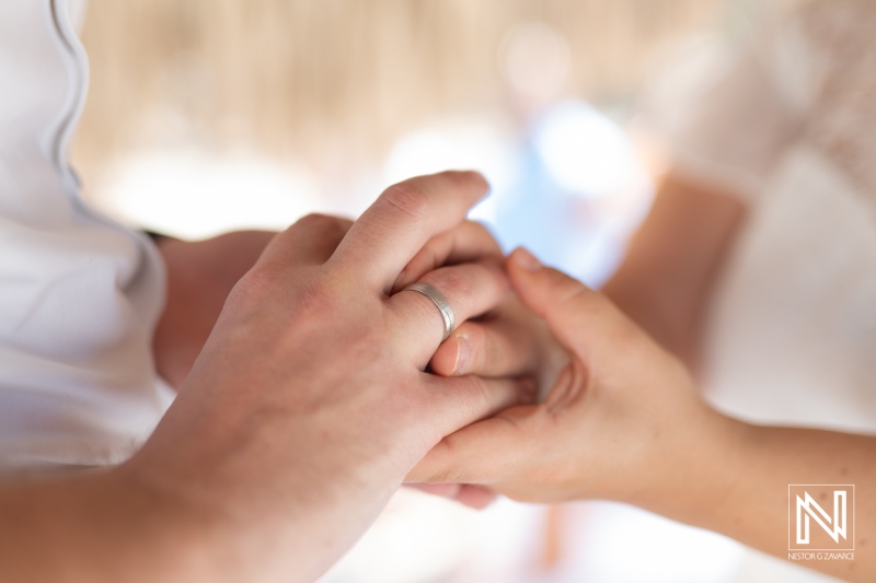 Wedding ceremony at Daaibooi Beach in Curacao with a couple exchanging rings during a heartfelt moment