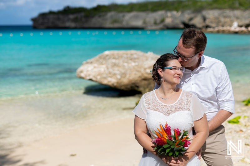 Couples celebrate their romantic wedding at Daaibooi beach in Curacao under a bright blue sky with clear ocean views