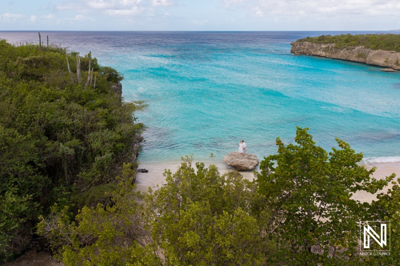 Beautiful wedding moment captured at Daaibooi Beach in Curacao amidst serene turquoise waters and lush greenery
