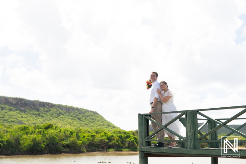 Couple celebrates wedding on scenic Daaibooi pier in Curacao under a vibrant sky