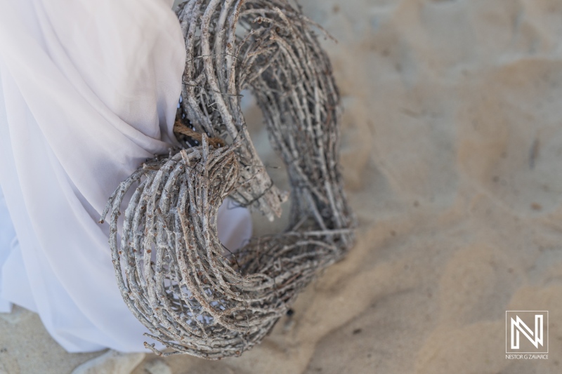 A Close-Up of a Heart-Shaped Wreath Made of Twigs Resting on Sand, Symbolizing Love, Decor, and Natural Elements During a Beach Wedding Setup in the Afternoon