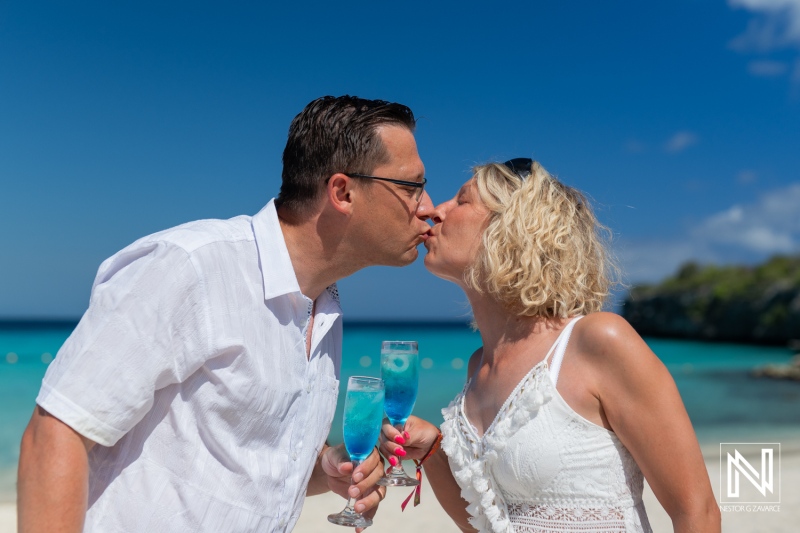 Couple Enjoys a Romantic Kiss on a Tropical Beach While Sipping Colorful Cocktails Under the Bright Blue Sky