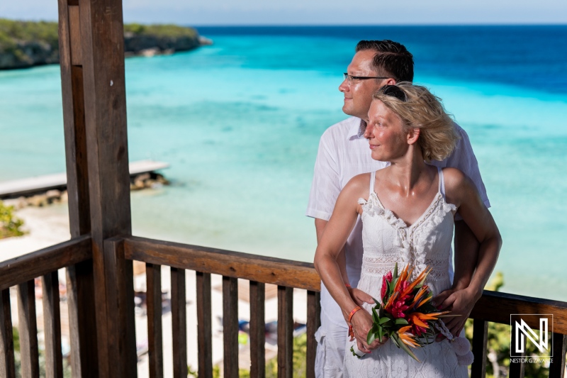 Couple Celebrating a Wedding Ceremony With a Beach Backdrop, Surrounded by Vibrant Tropical Scenery in a Serene Location During Bright Daylight