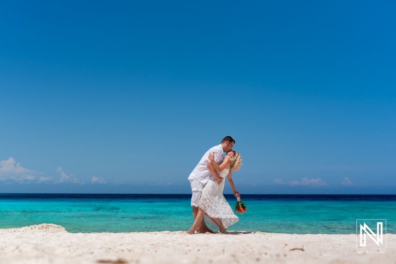 Couple Enjoying a Romantic Moment on a Tropical Beach With Clear Blue Waters During a Sunny Day, Featuring a Bright Sky and Vibrant Greens of the Ocean