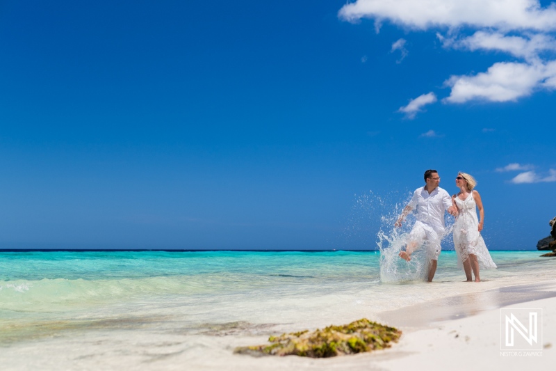 A Couple Enjoying a Playful Moment by the Turquoise Ocean Under a Clear Blue Sky on a Sandy Beach During a Sunny Day