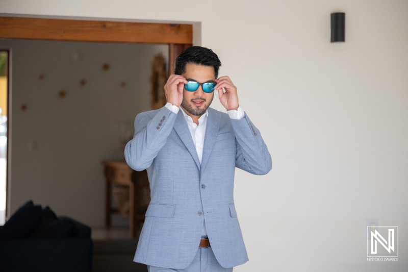 Wedding celebration at Playa Hunku in Curacao features groom getting ready with sunglasses on