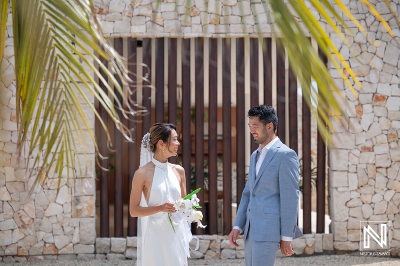 Couple exchanges vows at wedding in Playa Hunku, Curacao under bright sunlight