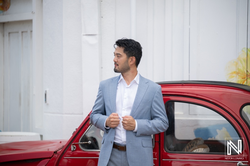 Wedding celebration at Playa Hunku in Curacao with a groom by a red car