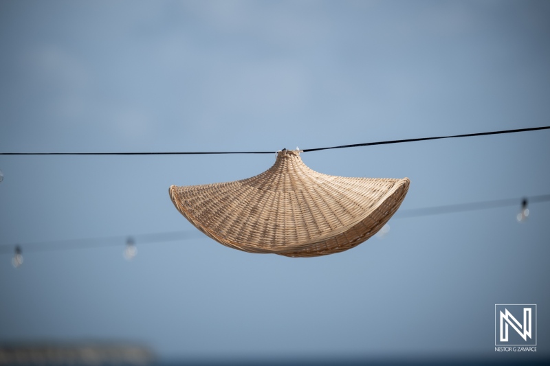 Wedding decor at Playa Hunku features woven hats hanging on strings against a clear sky