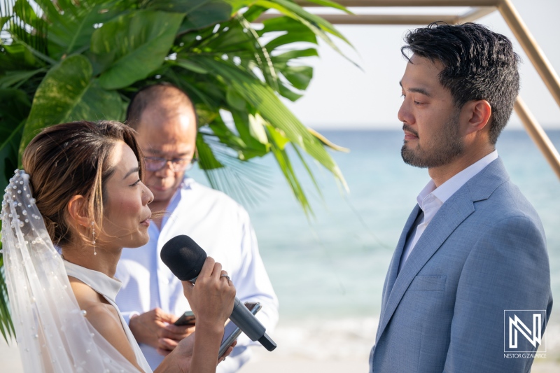 Couple exchanges vows during wedding ceremony at Playa Hunku in Curacao by the beach