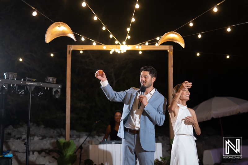 Couple speaks during wedding reception at Playa Hunku in Curacao under string lights