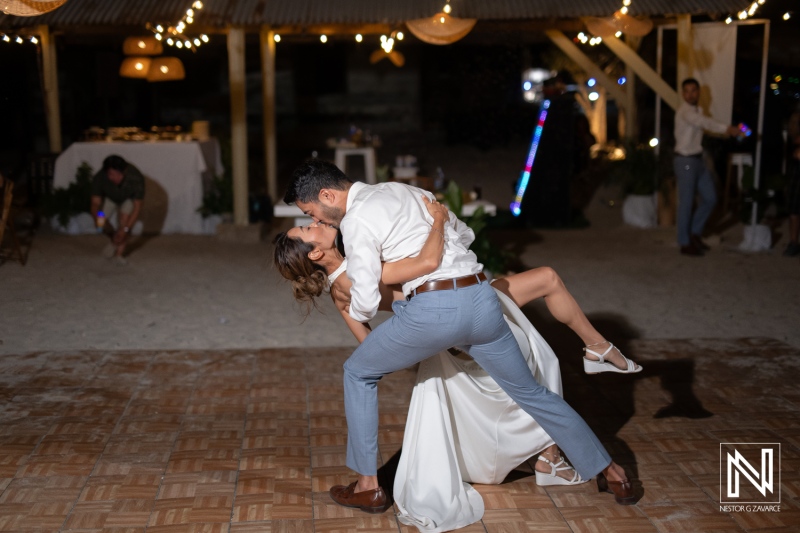 Couple dances joyfully at wedding celebration in Playa Hunku, Curacao
