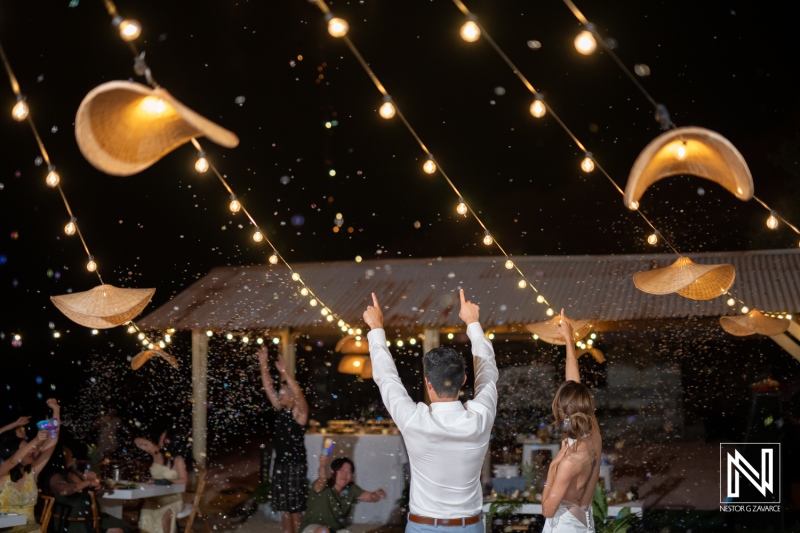 Couple celebrates wedding night in Playa Hunku, Curacao with friends and family during festive outdoor gathering