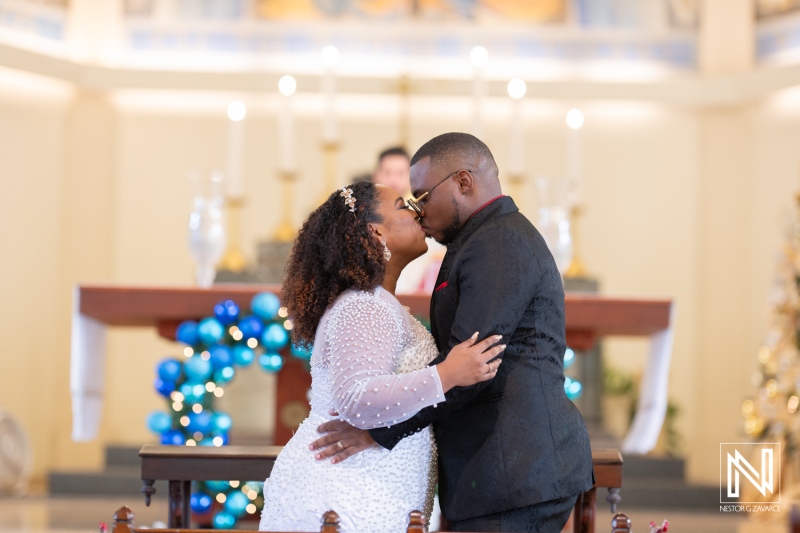 Wedding celebration in Curacao features a loving couple sharing a kiss during the ceremony inside a decorated venue