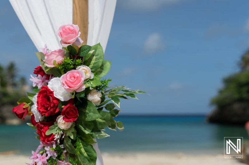 Beautiful Floral Arrangement Decorated With Roses and Greenery at a Beachside Location Ready for a Romantic Ceremony During a Sunny Afternoon