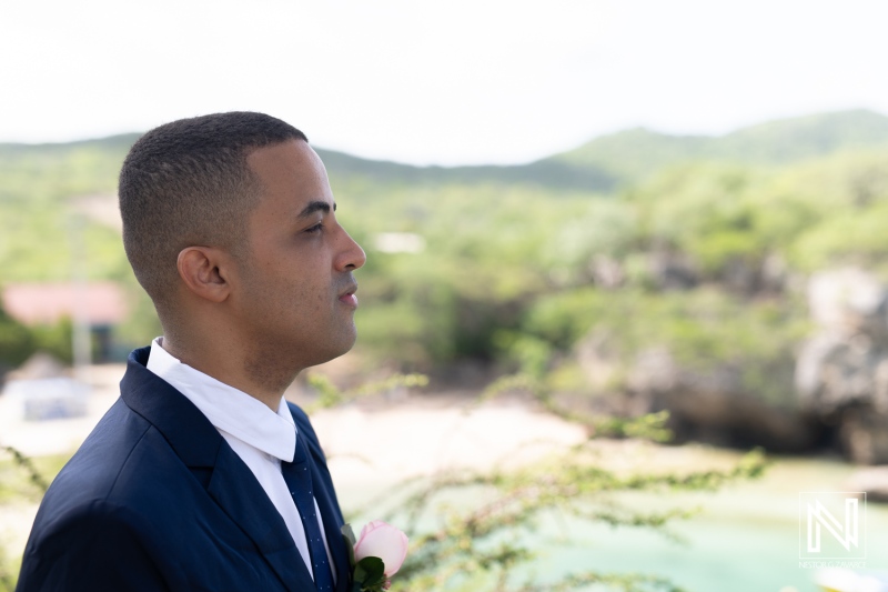 A Groom Stands Confidently by the Beach, Awaiting His Bride During a Picturesque Wedding Ceremony on a Sunny Day at a Tropical Destination