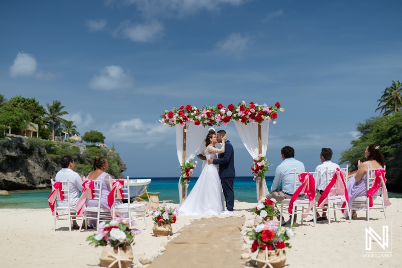 A Couple Exchanges Vows During a Romantic Beach Wedding Ceremony on a Sunny Day, Surrounded by Guests and Beautiful Floral Decorations