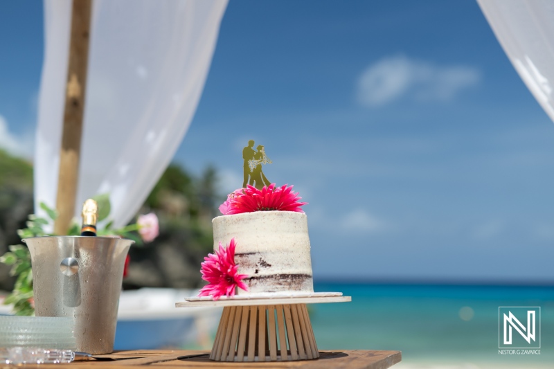 Beachside Wedding Cake Adorned With Flowers and a Couple Figurine at a Tropical Destination