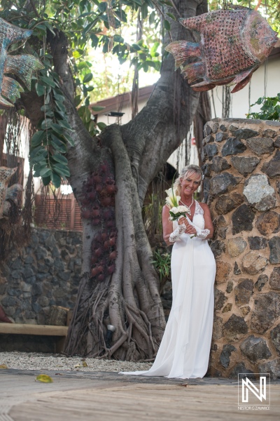 bride posing next to a tree