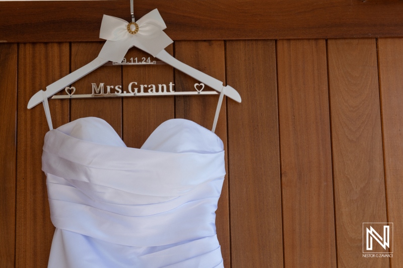 Elegant white wedding dress hanging on a hanger with a personalized name at a charming venue before the ceremony begins