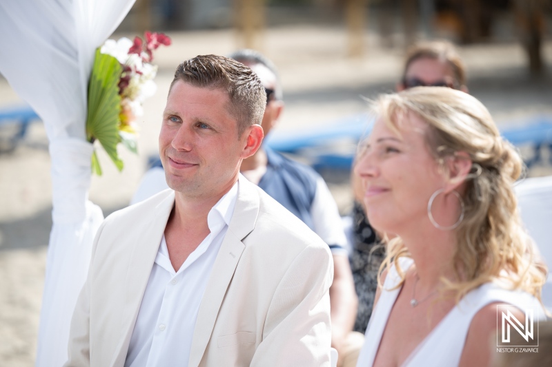 Couple smiles during wedding ceremony at Daaibooi Beach in Curacao at The Kontiki Beach Resort