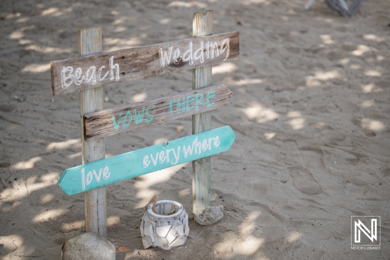 Wedding signs guide guests at Daaibooi Beach in Curacao during a beautiful beach ceremony at The Kontiki Curaçao Beach Resort