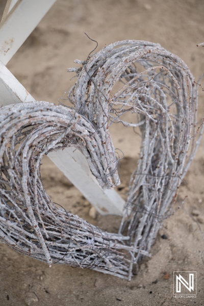 Wedding decorations at Daaibooi Beach in Curacao with heart shaped design made of twigs near the hot sun and sand