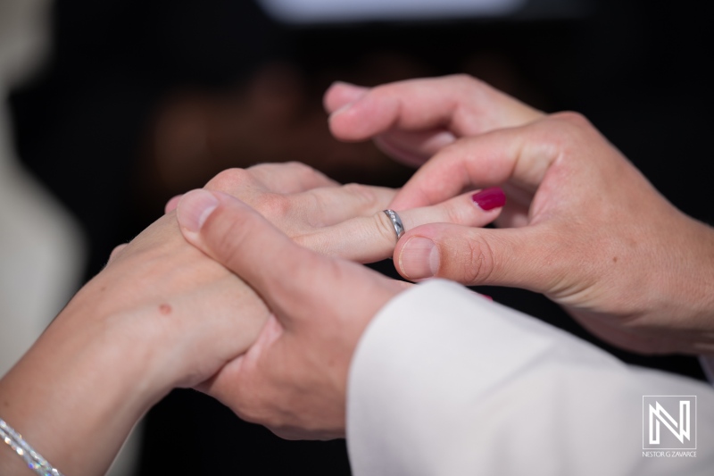 Couple exchanges wedding rings during ceremony at Daaibooi Beach in Curacao at The Kontiki Curaçao Beach Resort