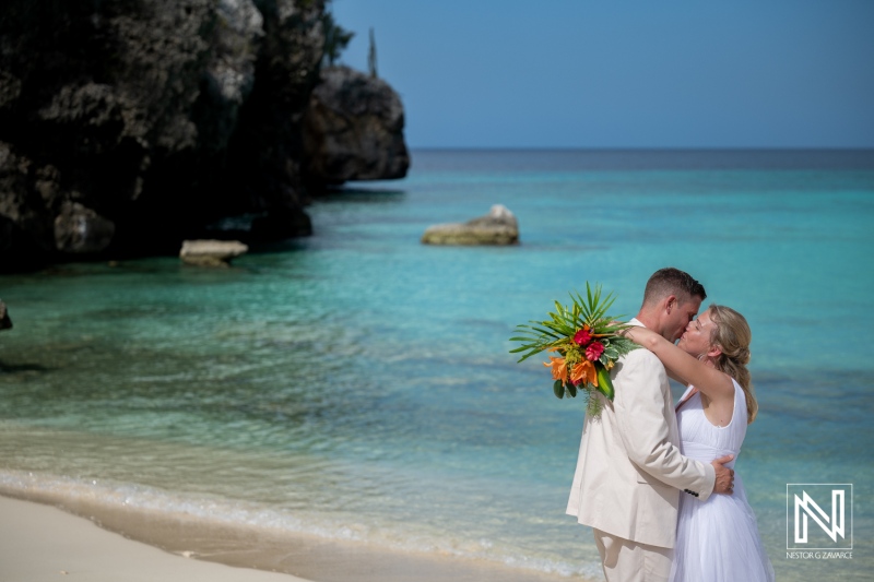 Wedding celebration at Daaibooi Beach in Curacao with couple enjoying the moment near the water and cliffs