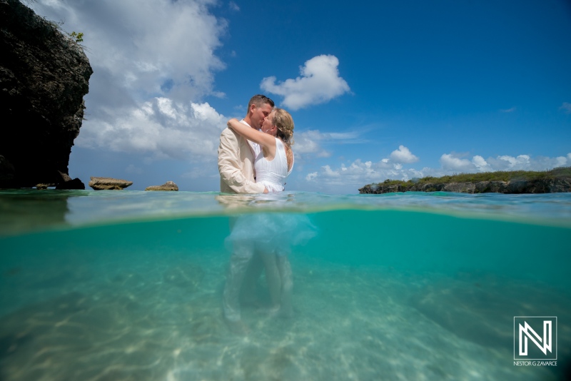 Couple celebrates their wedding at Daaibooi Beach in Curacao with a kiss in the water