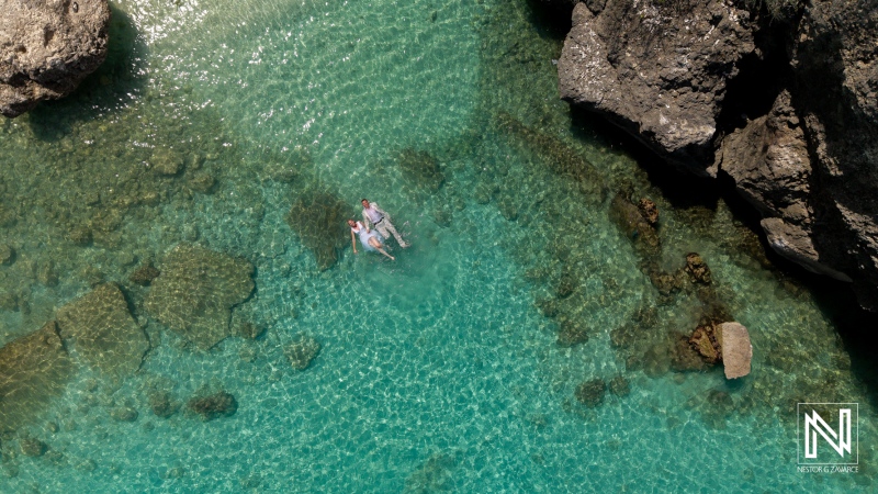Couple enjoys a warm day floating in the clear waters at Daaibooi Beach in Curacao near The Kontiki Curaçao Beach Resort