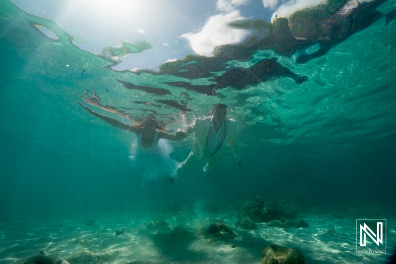 Couple swimming underwater at Daaibooi Beach during wedding ceremony in Curacao at The Kontiki Curaçao Beach Resort