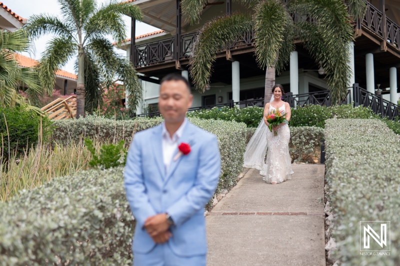 Couple prepares for a romantic wedding ceremony at Kokomo Beach in Curacao with lush greenery surrounding the joyous moment